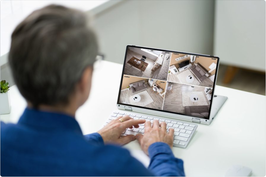 A man looking to videos from CCTV cameras on a monitor